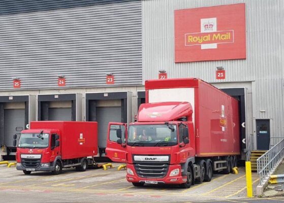 Delivery trucks loading at UK distribution centre for next day parcel service